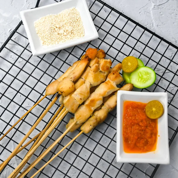 Sate Taichan, Grilled Chicken Satay without peanut sauce or soy sauce. Served on plate with sambal (chilli sauce). Selected focus.