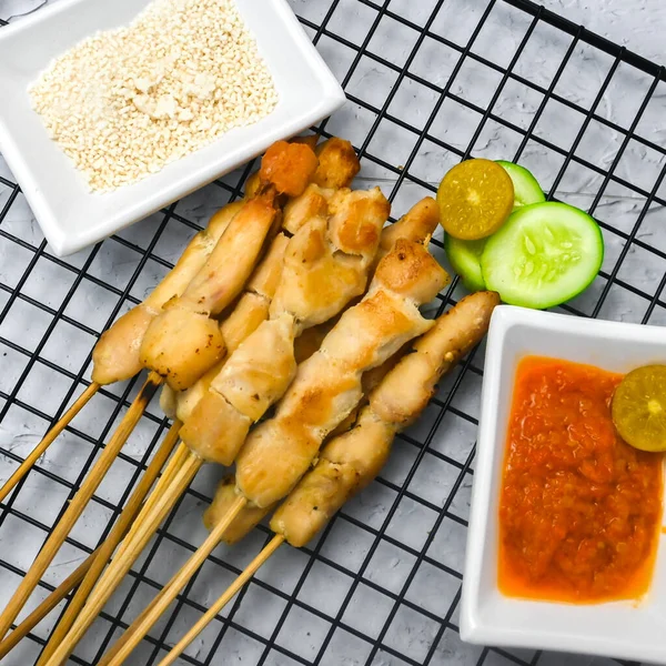 Sate Taichan, Grilled Chicken Satay without peanut sauce or soy sauce. Served on plate with sambal (chilli sauce). Selected focus.