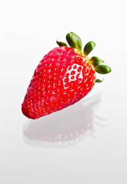 Bir fotoğraf stüdyosunda çekilen beyaz arkaplanda çekilmiş lezzetli bir çilek.