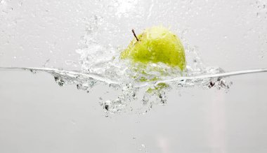 Bir elmanın su birikintisine girerken yüksek hızda görüntülenmesi