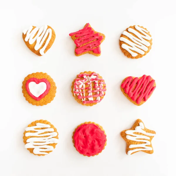 Sweet creative pattern made with vibrant pink cookies against bright white background. Bold delicious sugar cookies. Minimal flat lay sweets.