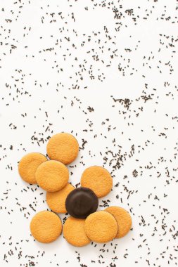 Stack of round cookies with chocolate sprinkles on white background. Process of making birthday cheesecake.