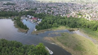 Panorama Augustowa z dron. Widok kanalu augustowskiego I plywajacych po nim statkow wycieczkowych, motorowek i zaglowek w letni sloneczny dzien.
