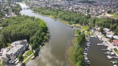 Panorama Augustowa z dron. Widok kanalu augustowskiego I plywajacych po nim statkow wycieczkowych, motorowek i zaglowek w letni sloneczny dzien.