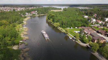 Panorama Augustowa z dron. Widok kanalu augustowskiego I plywajacych po nim statkow wycieczkowych, motorowek i zaglowek w letni sloneczny dzien.