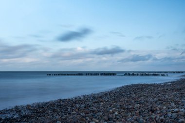 Kolobrzeg 'de Baltık Denizi kıyısındaki dalgakıran ve taşların Baltık Denizi manzarası.