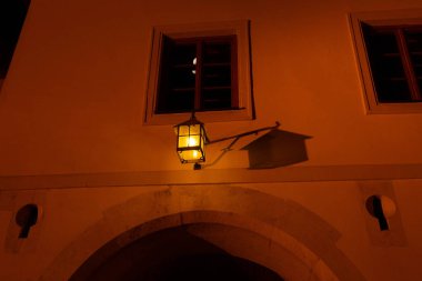 Aydınlatılmış bir pencerenin düşük açılı görüntüsü ve ışık ışınlı bir fener.