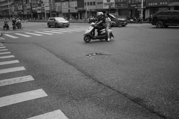 市内のスクーターに乗っている若者の白黒写真です — ストック写真