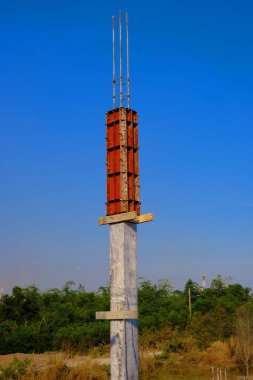 İnşaat alanında güçlendirilmiş beton kolonlar. İnşaat işçileri inşaat sütunları için çelik kaplama döşüyorlar
