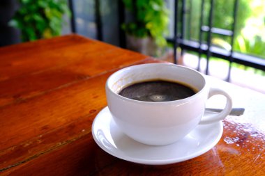 Sade kahve ve beyaz bir seramik bardak ahşap bir masada..