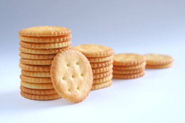 Krakerler ya da bisküviler dikey sırada dizilir ve biri beyaz arkaplana yaslanır.