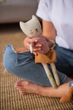 Elinde oyuncak ayıyla beyaz bir arka planı olan bir kadın.