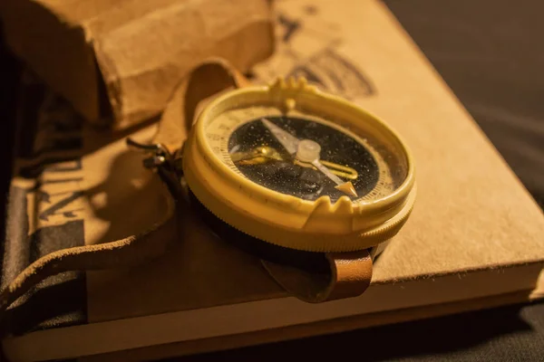 Bir kitabın üzerinde eski moda deri kayışlı bir pusula