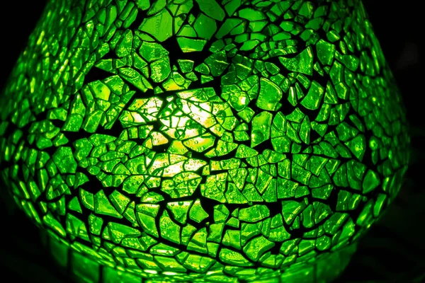 İçinde yeşil mozaik olan vazo karanlıkta arka planda, kabarcıklar içinde.