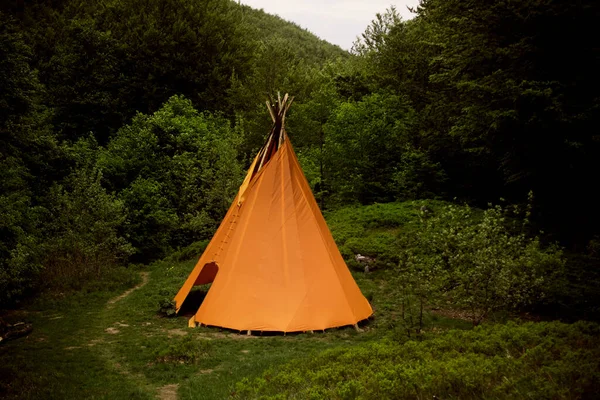 Dağlardaki yerlilerin ahlâki konutları yeşil bir çayırda..
