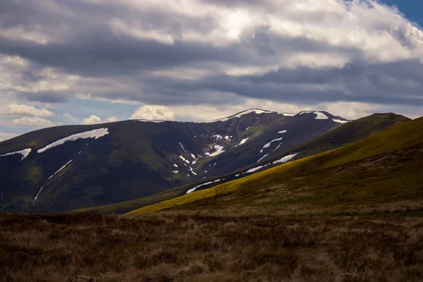 Karla kaplı derin bir vadi, asılı duran gök gürültülü bulutlar..