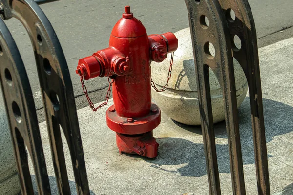 Red hydrant in front of the wall with gas tank