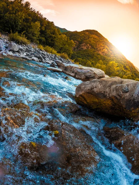 Paesaggio bellissimo emozionante, fiume d'acqua di montagna, sole al tramonto nella natura