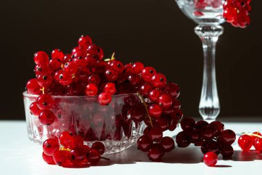 red currant berries in a crystal bowl on a black background
