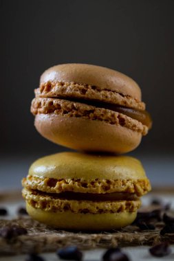two small colored macaroons on a dark background