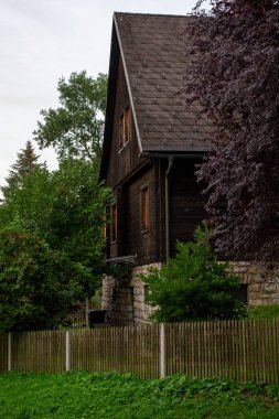 wooden house in the alpine forest at the foot of the mountains