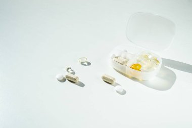 Çeşitli ilaç ve kapsüllerle dolu beyaz ilaç deposu.