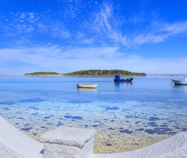 Salento sahili: İtalya 'nın Apulia kentindeki Porto Sezeryan limanı manzarası. Arka planda Tavşanlar Adası: burada tamarisks ormanı ve sualtı dünyası hayran mümkün.