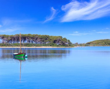 Salento sahili: İtalya 'nın Apulia kentindeki Porto Sezeryan limanı manzarası. Arka planda Tavşanlar Adası: burada tamarisks ormanı, çam ve sualtı dünyası hayran mümkündür.