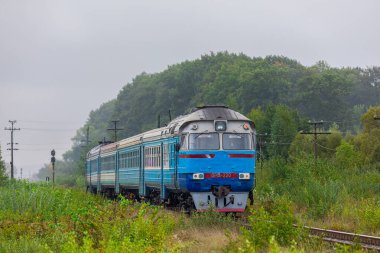 Khodorov, Ukrayna - 2021 sonbaharı: Banliyö yolcusu çoklu dizel tren DR1A tren istasyonuna ulaşır. Bulutlu sonbahar havası.