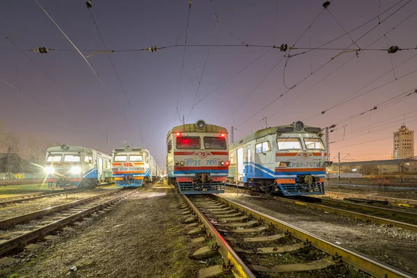 Kharkiv, Ukrayna - İlkbahar 2021: İstasyonun çıkışını bekleyen dört adet ER2 elektrikli tren durağı. Ukrayna demiryolları. Akşam fotoğrafı.