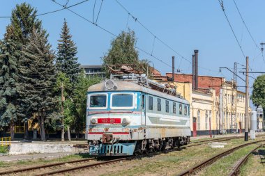 Kharkiv, Ukrayna - Yaz 2021: Paslı eski bir elektrikli lokomotif Skoda ChS2 bir lokomotif deposunun bölgesinde duruyor. Güneşli fotoğraf.
