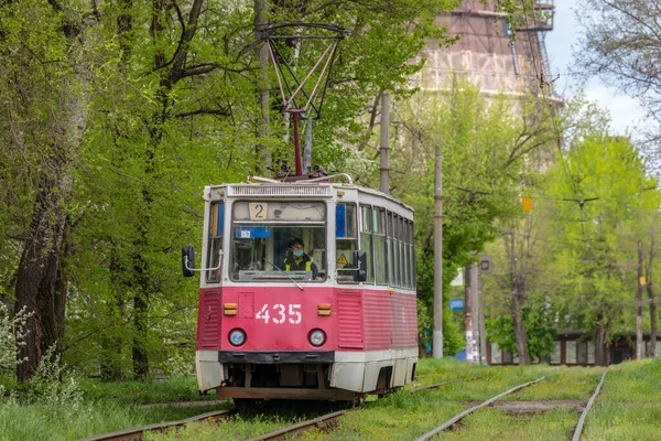 Kryvyi Rih, Ukrayna - 2021 Baharı: Eski güzel kırmızı 71-605 tramvay rayları üzerinde yeşil ağaçların arka planına doğru gidiyor. Yakın çekim görünümü.