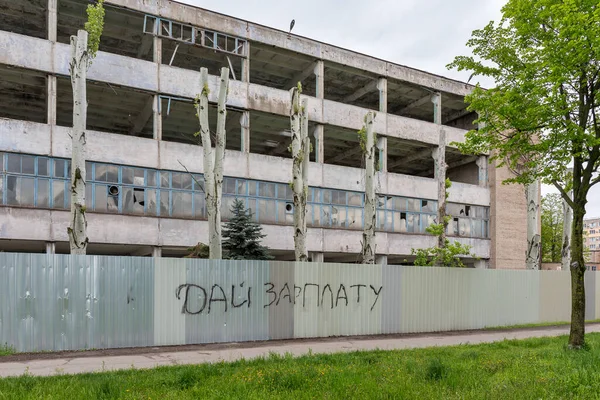 Kryvyi Rih, Ukrayna - 2021 Baharı: Çalışmayan bir işletmenin yok edilmiş atölyesi. Taşra 'da. Taşra sanayi şehri. Çitteki yazı 