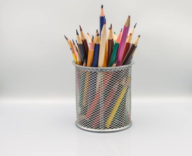 Beyaz bir masada bir sürü renkli kalem var.