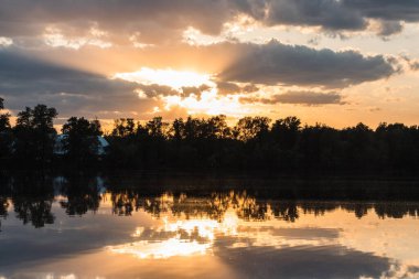 Sunset on the banks of the Dnieper River. Natural landscape. Nature in Ukraine. Reflection, blue sky and yellow sunlight. landscape during sunset.