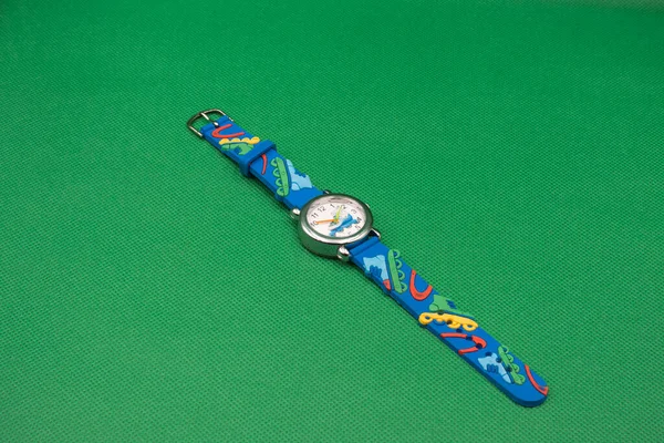 Çocuklar yeşil bir arkaplanda izliyorlar. Yeşil arka planda mavili akıllı saat. Yakın plan..