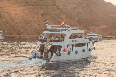 SHARM EL SHEIKH, EGYPT - 7 Haziran 2021: Sharm El Sheikh, Mısır 'da Kızıldeniz körfezinde turistlerle lüks yatlar. Bazı turistler zengin sualtı dünyasıyla mercan resiflerini görmek için şnorkelle yüzüyor..