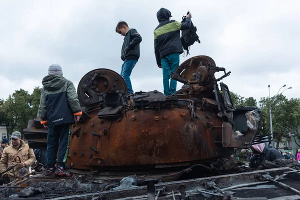 KYIV, UKRAINE - Mayıs. 22, 2022 Kyiv 'de Rus tanklarını ve diğer askeri teçhizatını imha edip yaktı. Çocuklar imha edilmiş bir tankla oynuyorlar.