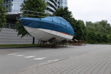 Mavi kapaklı bir motorlu tekne ağaçların arka planına karşı açık gökyüzünün altında duruyor..