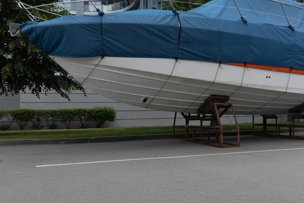 Mavi kapaklı bir motorlu tekne ağaçların arka planına karşı açık gökyüzünün altında duruyor..