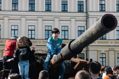 KYIV, UKRAINE - 3 Haziran 2022: Rus tankını Kyiv 'de yok etti ve yaktı. Çocuklar imha edilmiş bir tankla oynuyorlar..