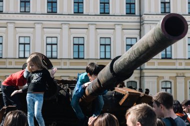 KYIV, UKRAINE - 3 Haziran 2022: Rus tankını Kyiv 'de yok etti ve yaktı. Çocuklar imha edilmiş bir tankla oynuyorlar..