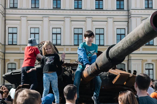 KYIV, UKRAINE - 3 Haziran 2022: Rus tankını Kyiv 'de yok etti ve yaktı. Çocuklar imha edilmiş bir tankla oynuyorlar..