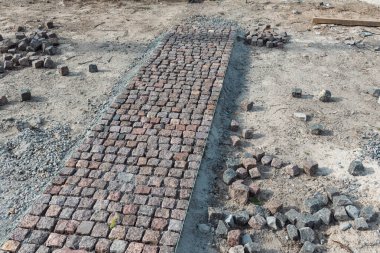 Taş kaldırım, inşaat işçisi kumlara taş döşeyen kaldırım taşları..