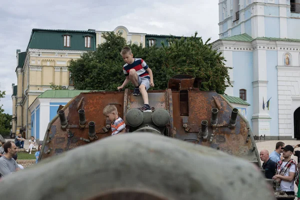 KYIV, UKRAINE - Haziran 06, 2022: Rus tankını Kyiv 'de yok etti ve yaktı. Çocuklar imha edilmiş bir tankla oynuyorlar..