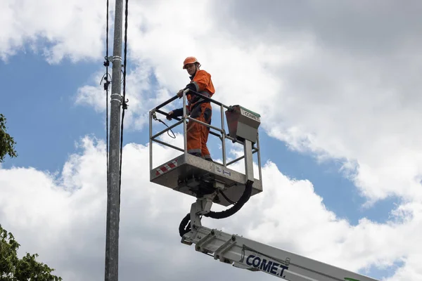 KYIV, UKRAINE - Haziran. 14, 2022: Özel bir kaldırma platformunda bir elektrikçi bir sokak lambasını tamir ediyor.