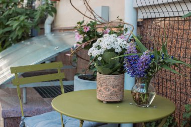 Vazodaki bahar çiçekleri. Teras 'ta cam vazoda bir buket çiçek..