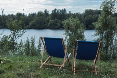 Nehir kenarında rahat piknik sandalyeleri. Nehir kıyısında iki güverte sandalyesi. Ukrayna.