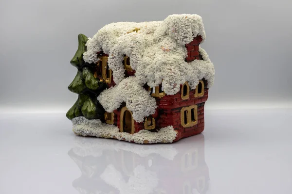 Small house with snow on a white background. New Year theme. Closeup.