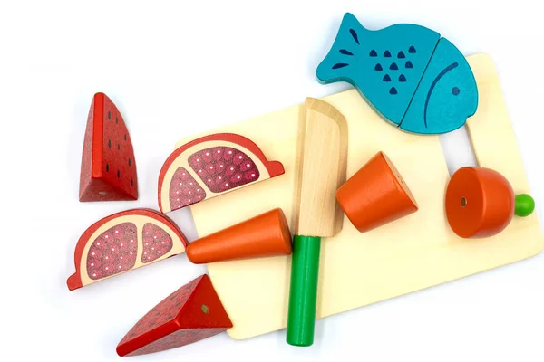 kids toy wooden vegetables in background close up. children's developing wooden game. a set of wooden vegetables. children's plastic toy kitchen. sliced toy vegetables
